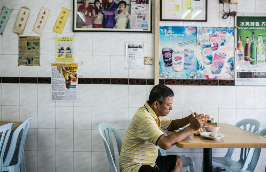 A diner enjoying his chicken rice meal at the shop.
